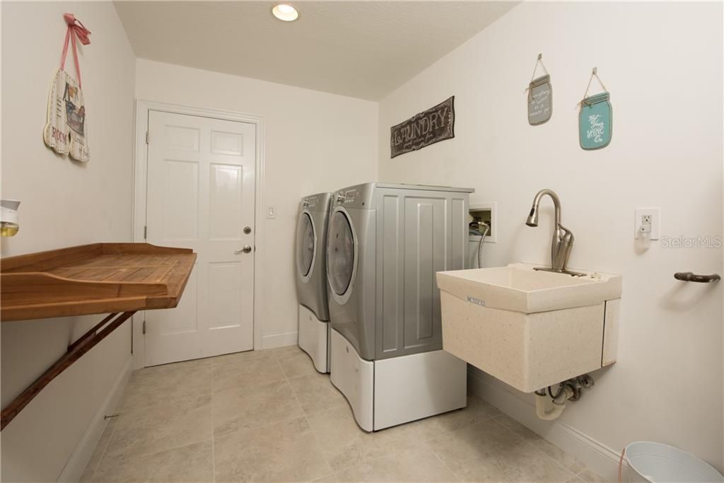 Laundry area with washer, dryer, utility sink and fold down folding table.