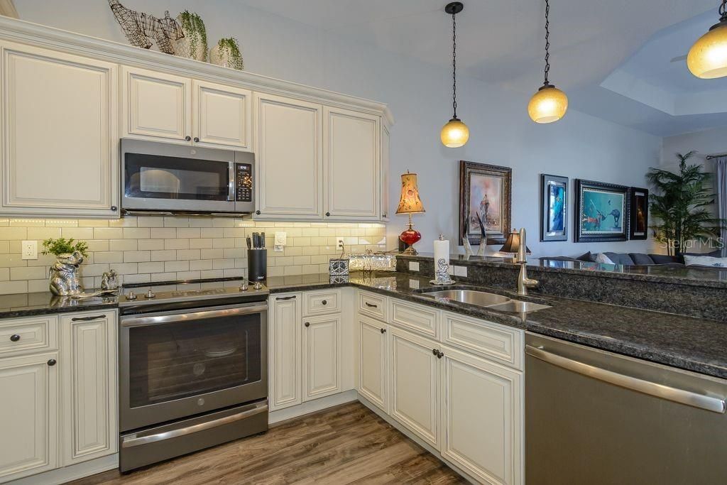 A light grey subway tile backsplash and custom light fixtures provide the finishing touch in the kitchen.