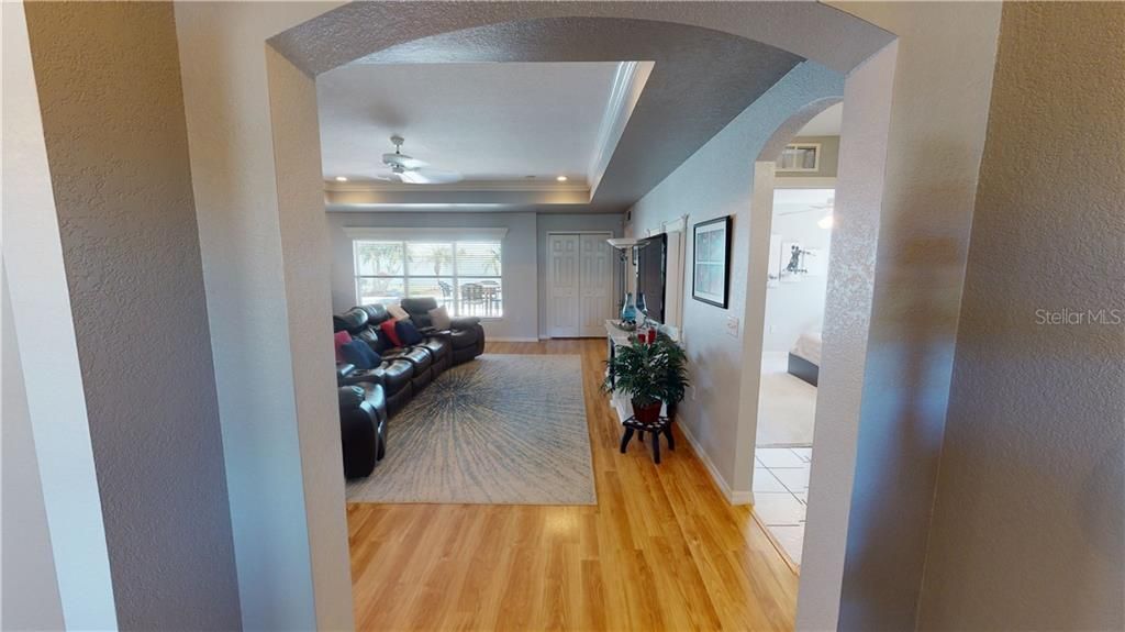 View from hallway into living room with tray ceiling
