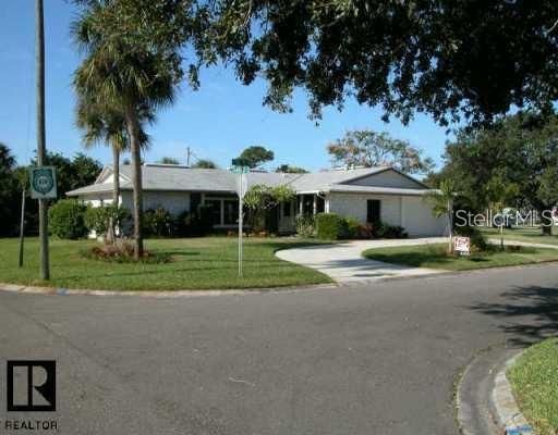 The home sits on a large corner lot with lovely landscaping and a circular driveway.