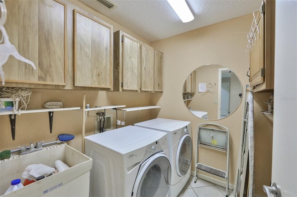 Inside Utility Room w/laundry tub & storage cabinets