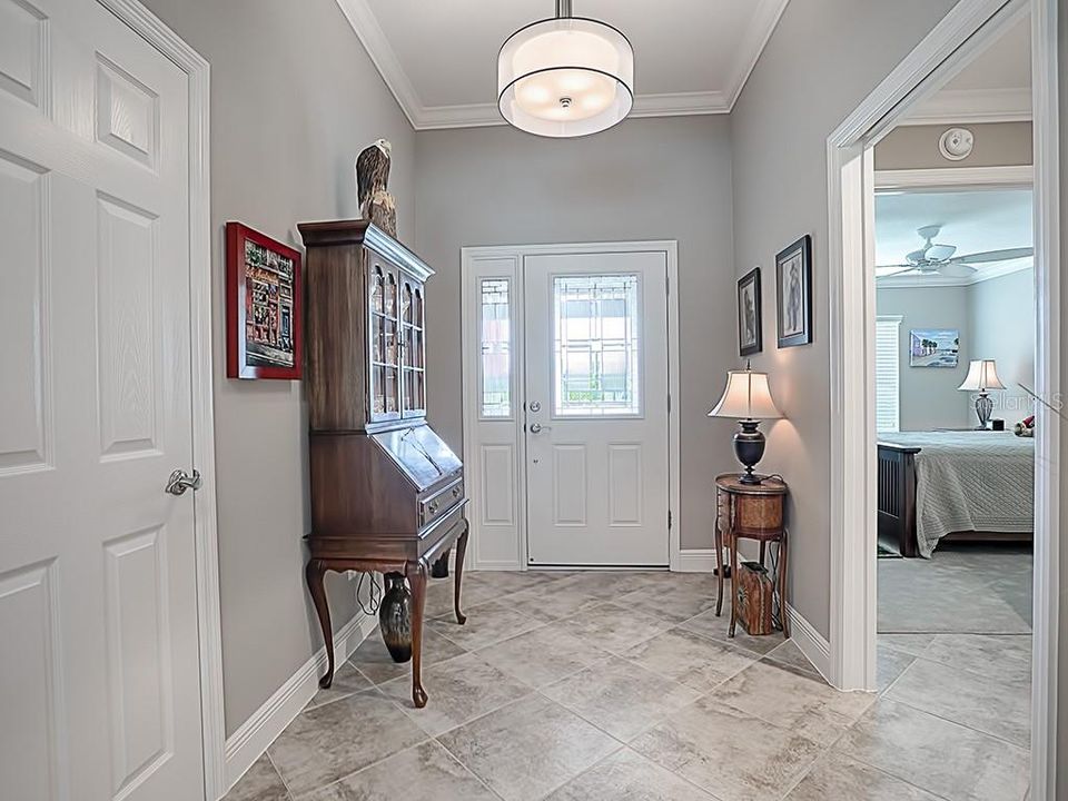 NICE FOYER WITH LEADED GLASS DOOR AND SIDE LITE. COAT CLOSET!! POCKET DOOR TO THE RIGHT LEADES TO ONE GUEST ROOM AND GUEST BATH!