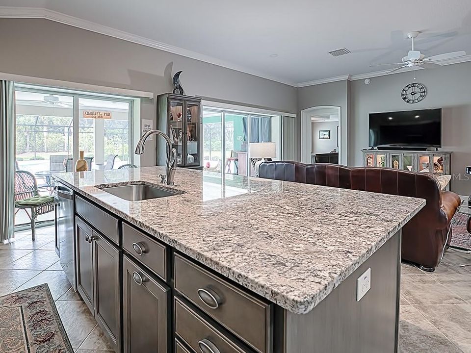 LOVELY ISLAND DESIGN KITCHEN WITH GRANITE COUNTERS AND VIEW OF THE LANAI AND POOL!