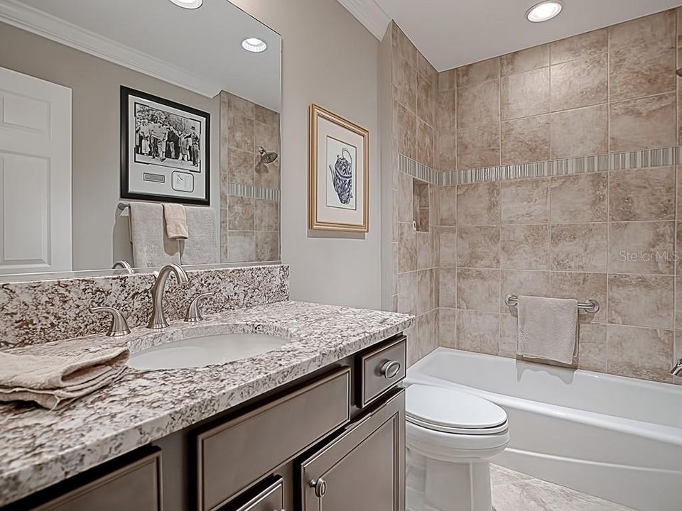 TILE TUB/SHOWER COMBO IN THE 2ND GUEST BATHROOM WITH GRANITE COUNTERS.