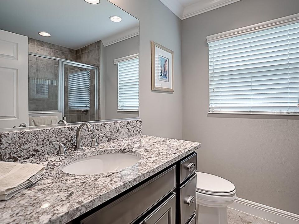 FRONT GUEST BATH WITH LARGE SHOWER AND GRANITE COUNTERTOPS.