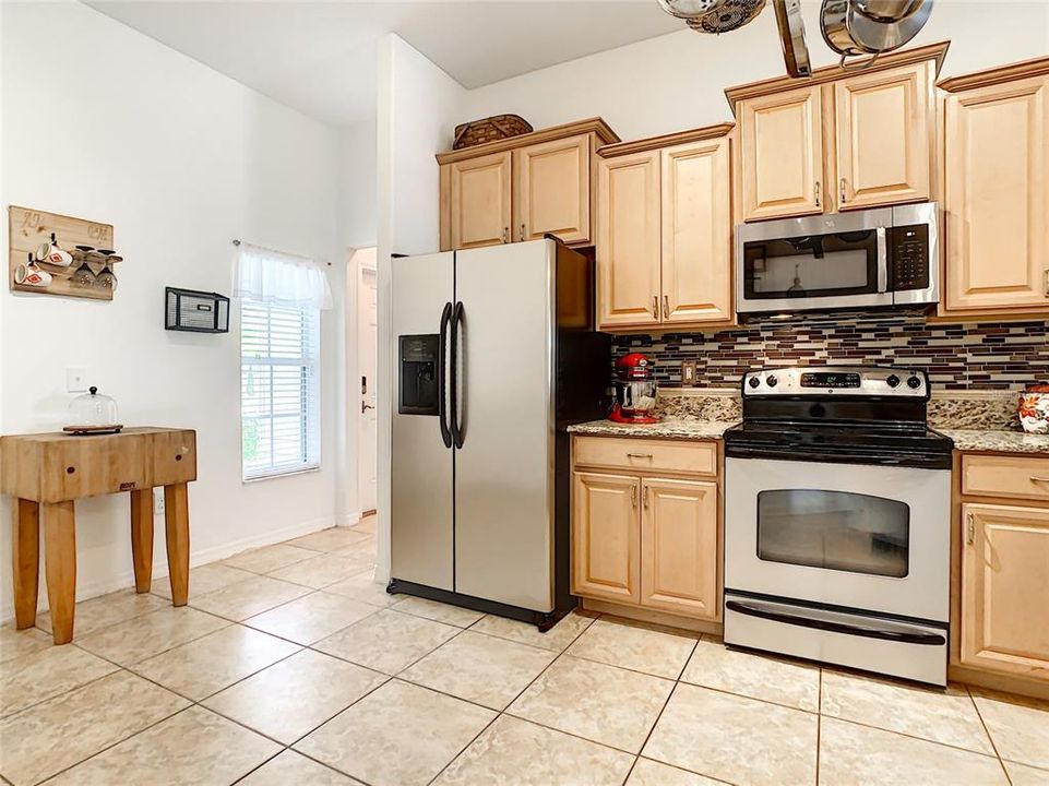 Kitchen with room for eat in table for two - staggered 42 inch upper cabinets and stainless steel appliances