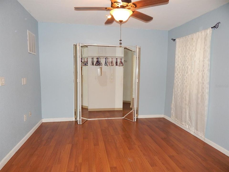 Master bedroom with mirrored closet doors.