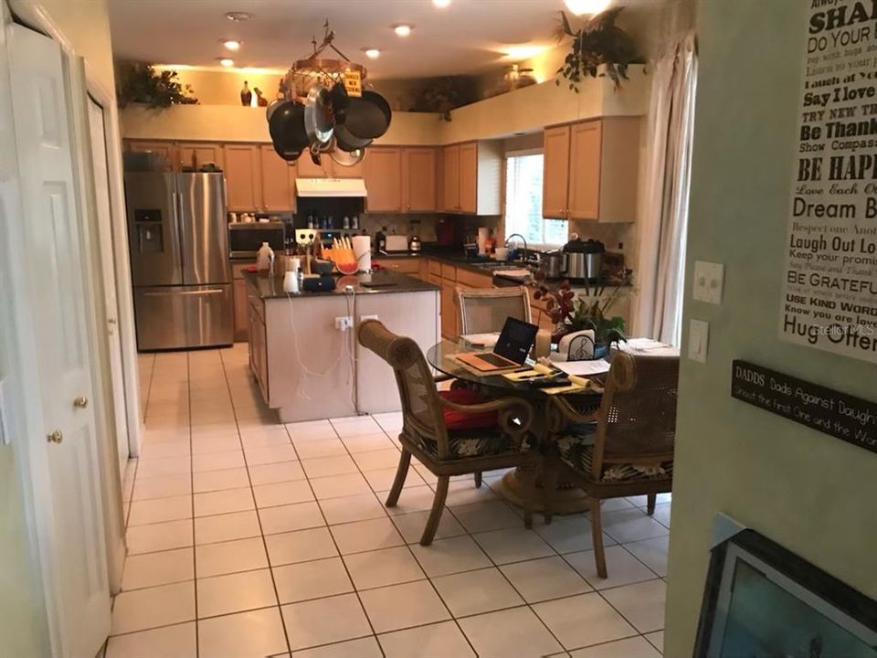 Standing next to bar on the right between the family room and kitchen