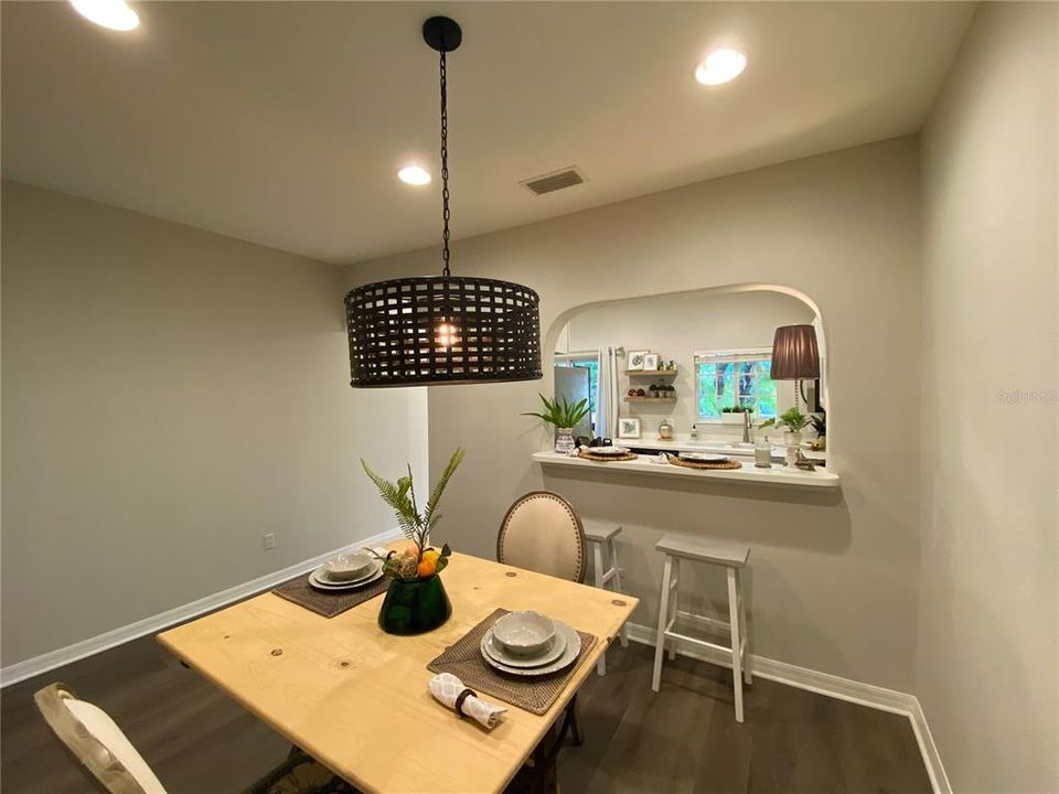 Spacious dining area with new flooring, lighting and breakfast bar with garden view