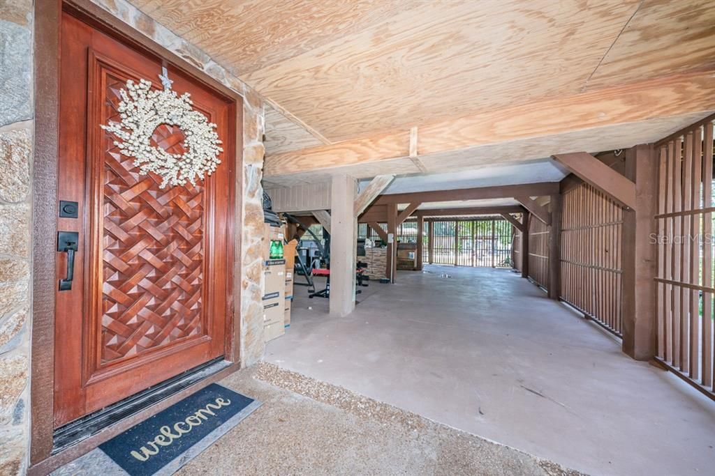 Entrance to front door and looking toward back yard. This area has a workshop, 2 car garage, outdoor kitchen/cooking/bar and poolside entertaining area