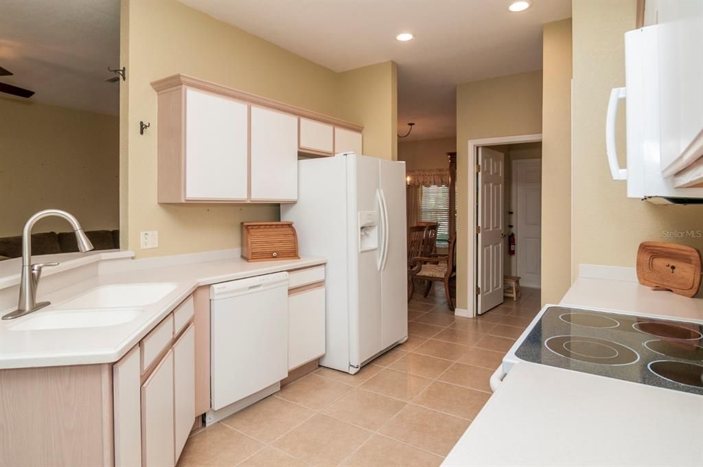 The kitchen features upgraded appliances and Corian counters. A crown molding enhances the cabinetry.