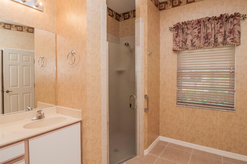 The master bath has 2 sinks with cultured marble tops and a stall shower with glass shower door.