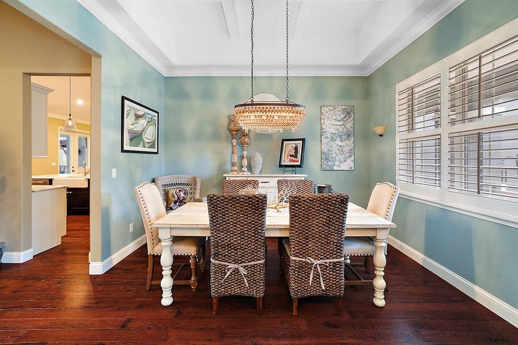 Dining Room with Crown Molding, Plantation Shutters and Wood Floors
