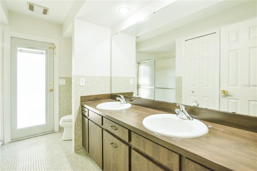 Third bathroom has dual sinks, pool access, walk in shower and linen closet.