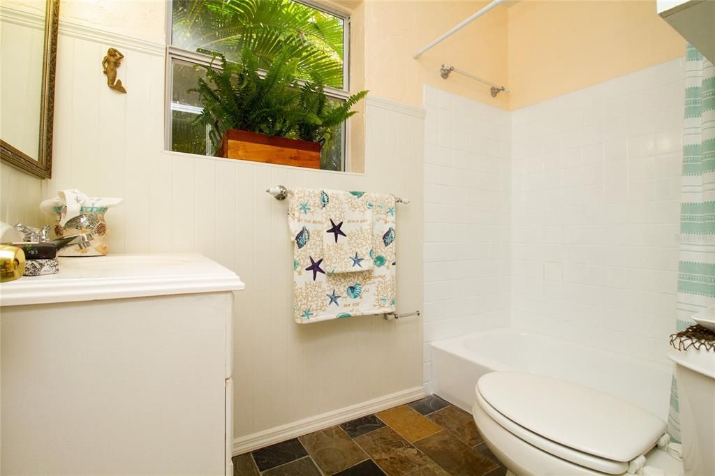 Pretty, functional, light and bright with a pretty view of the tall palms and tropical foliage. Tile shower tub surround, bead board, and slate tile ...