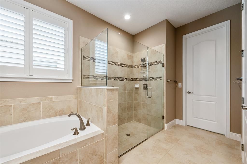 The PRIMARY EN-SUITE BATH offers DUAL SINKS, SOAKING TUB, TILE SHOWER with FRAMELESS GLASS DOORS and a WALK IN CLOSET with BUILT IN customized shelving!