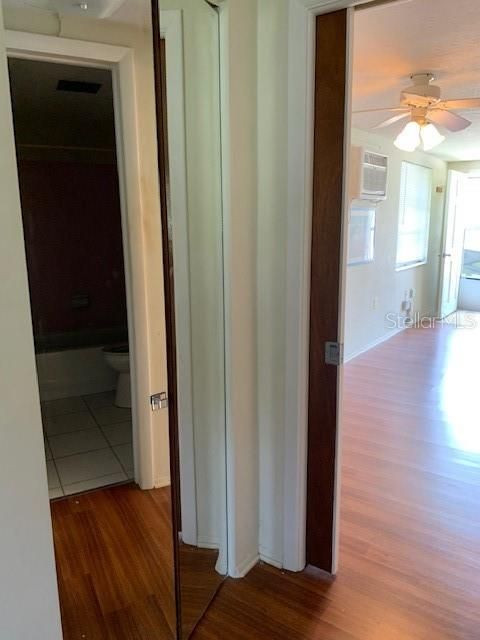 inside bedroom looking out.  Pocket Door, mirrored closet on the left, bathroom to the right