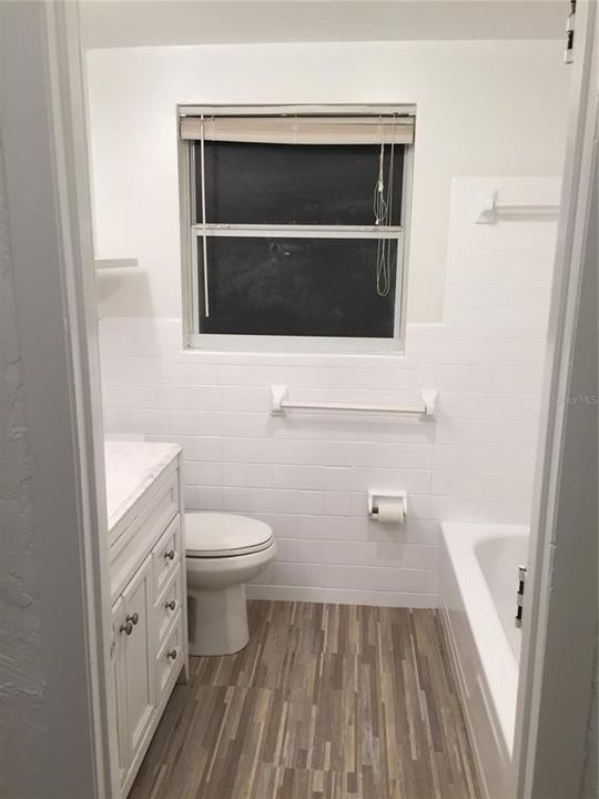 Fresh and clean bathroom with shower/tub combo.