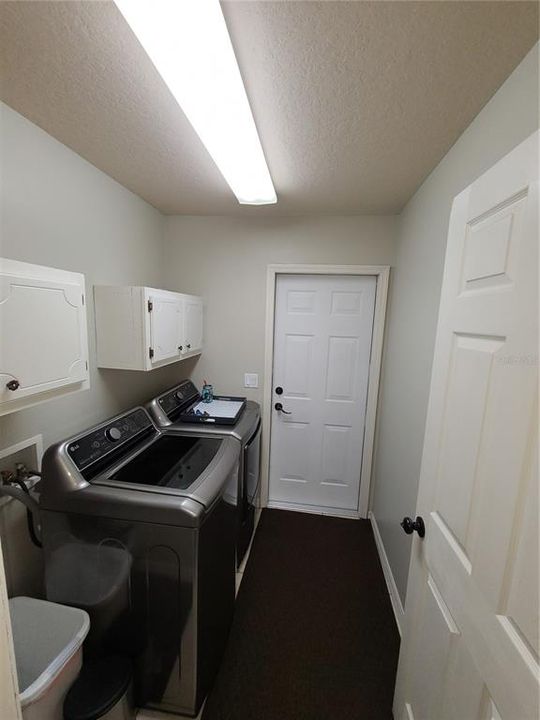 Laundry room with cabinets and door leading to garage
