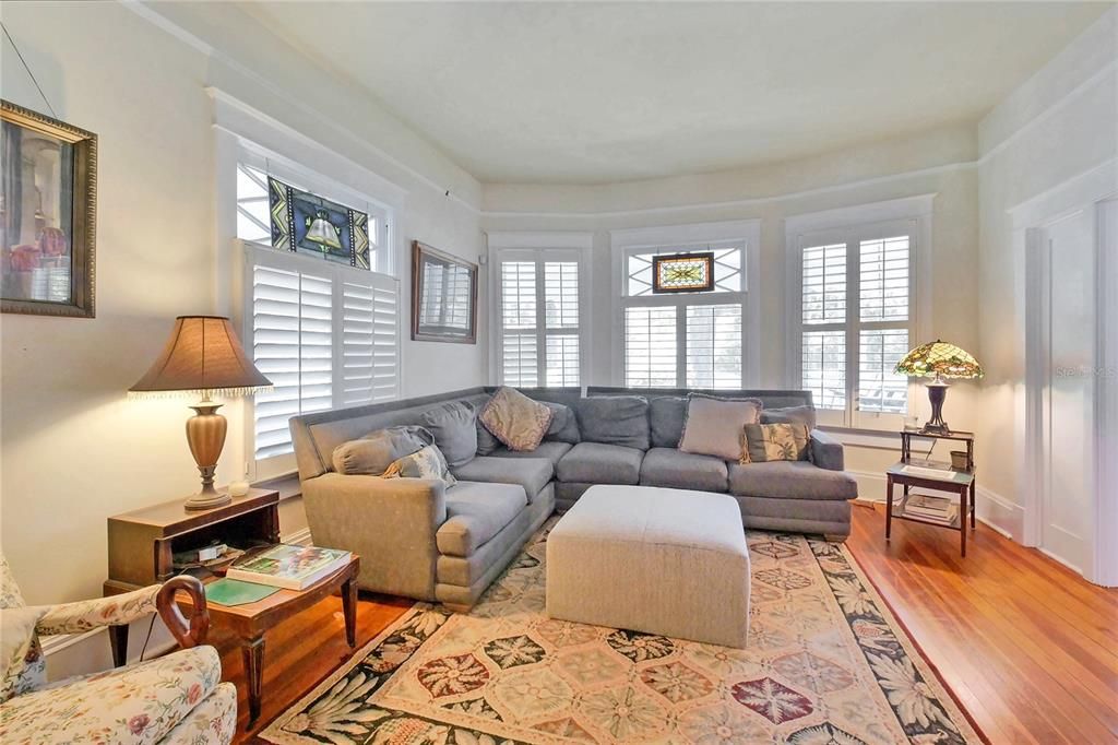 Light and bright living room with beautiful heart pine floors, tall floor moldings, and tall ceilings.