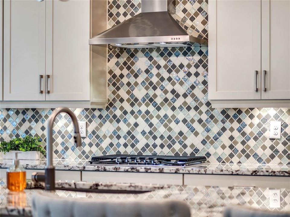 Timeless backsplash, vented stainless steel hood and natural gas cooktop !!