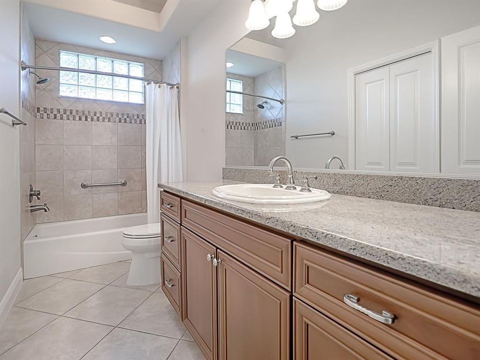 GUEST BATH WITH GRANITE COUNTERTOPS AND TUB/SHOWER COMBO.