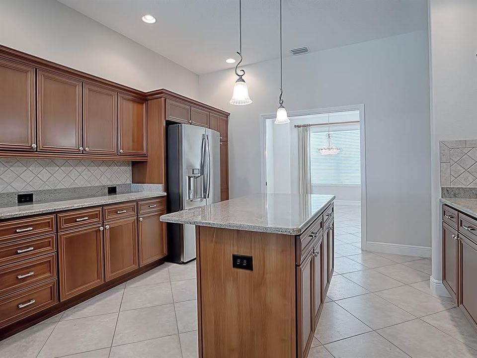 TILE BACKSPLASH, GRANITE COUNTERTOPS AND SOLID WOOD CABINETS WITH POT DRAWERS IN THIS SPACIOUS KITCHEN!