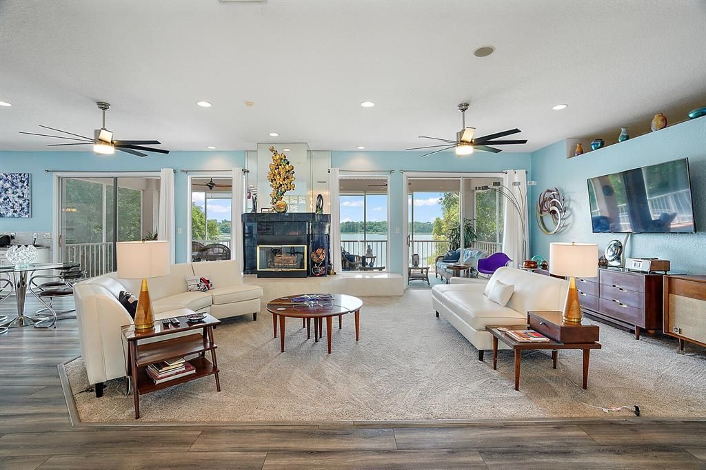 The welcoming main floor living area boasts an open floor plan with a wood-burning fireplace engulfed by an abundance of picture windows and glass sliders that lead to an 11x35 covered screened porch.