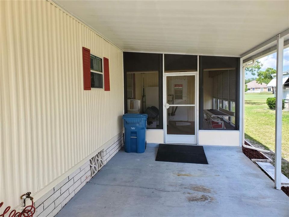 Covered carport/porch with screened patio towards rear of home
