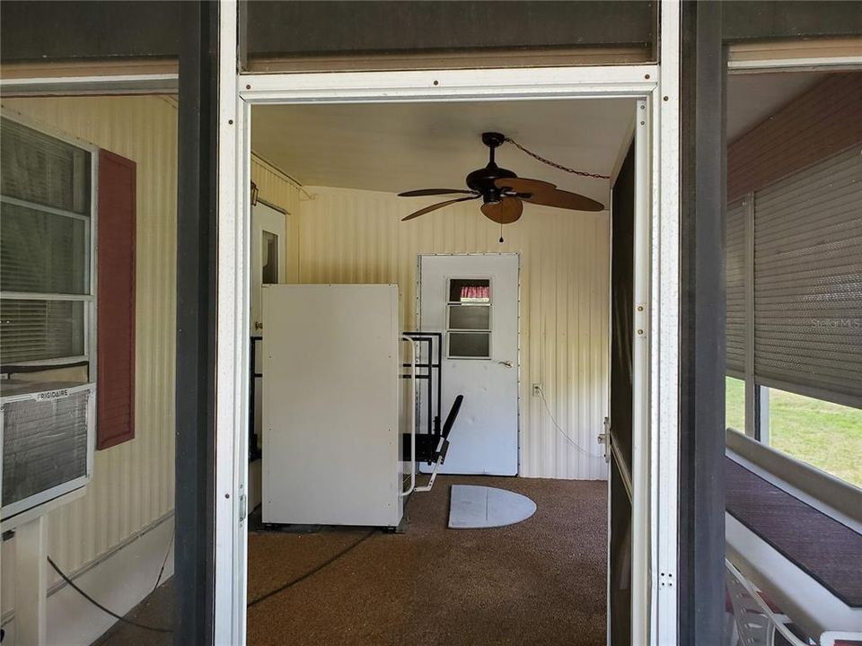 Covered patio/porch room with electric wheelchair lift near kitchen door