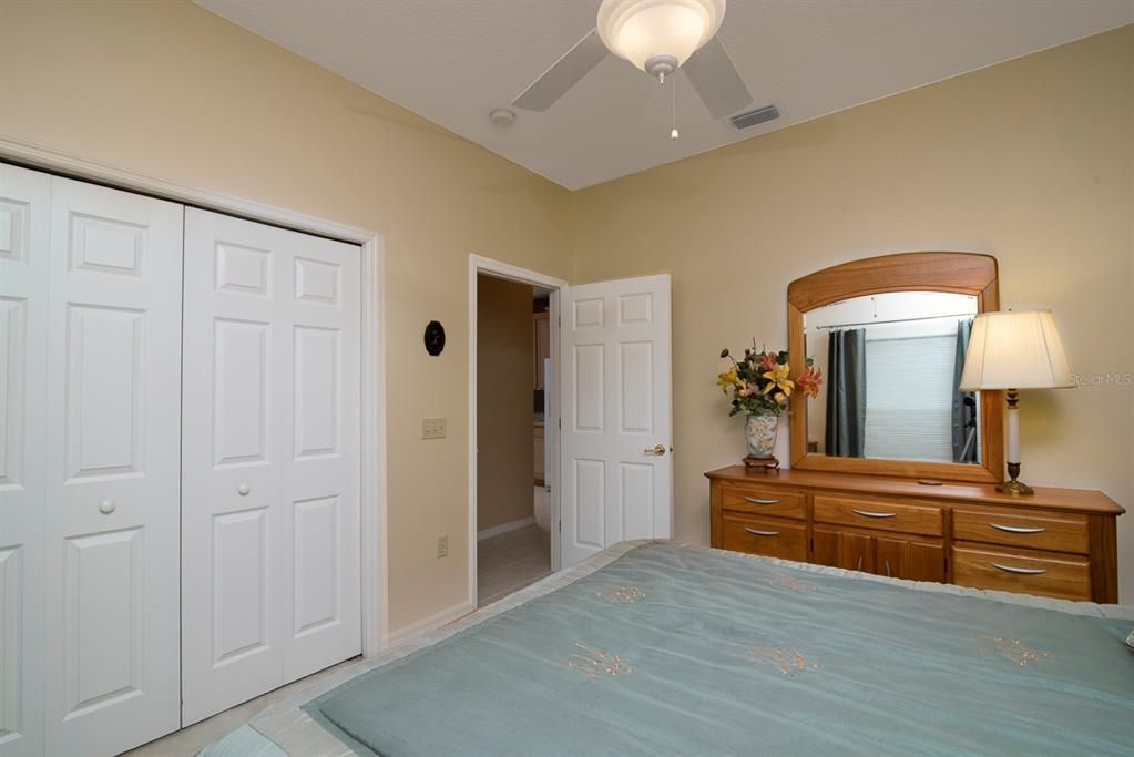 The guest bedroom has a large reach in closet, ceiling fan with light and quality carpeting.