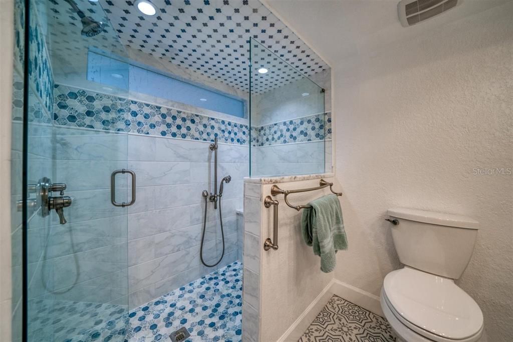 Huge shower with multiple shower heads and bench seating