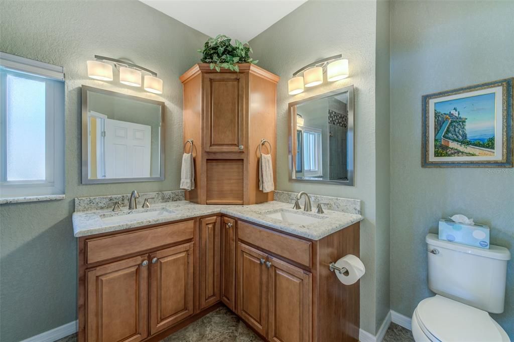 Dual sinks in the owner's bath are separated by a storage tower with tambour door.