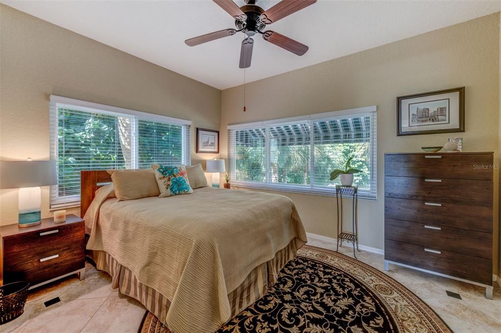 The guest bedroom on the living/dining/kitchen floor has huge windows and tropical views as the result of its end-unit location.