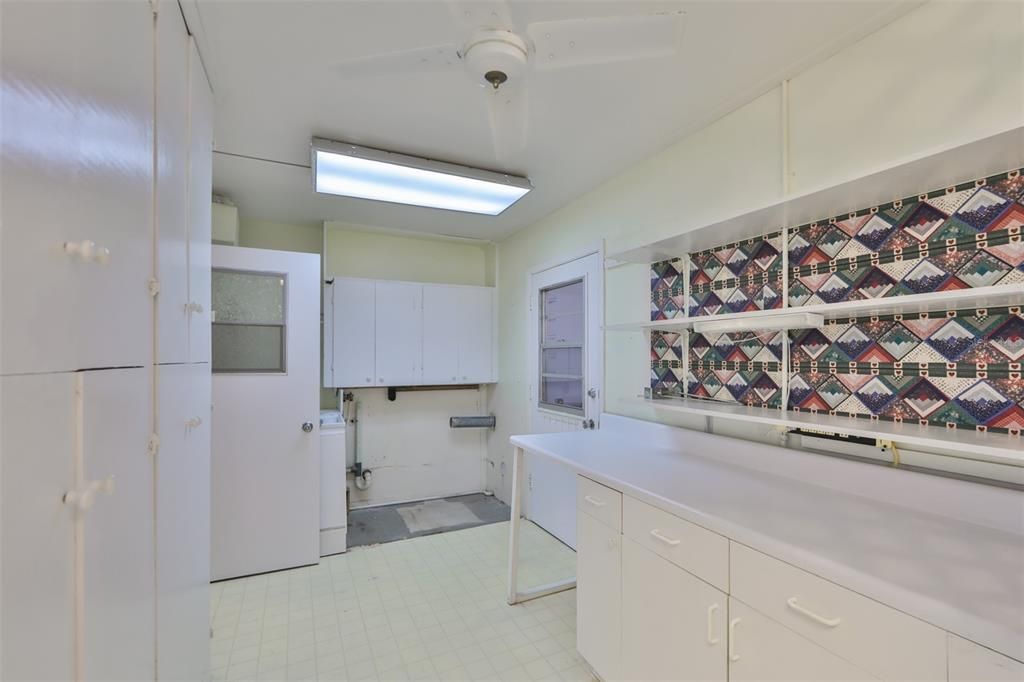 Laundry room is spacious and bright.  A utility sink is behind the door.  To the right is the door leading to the garage.