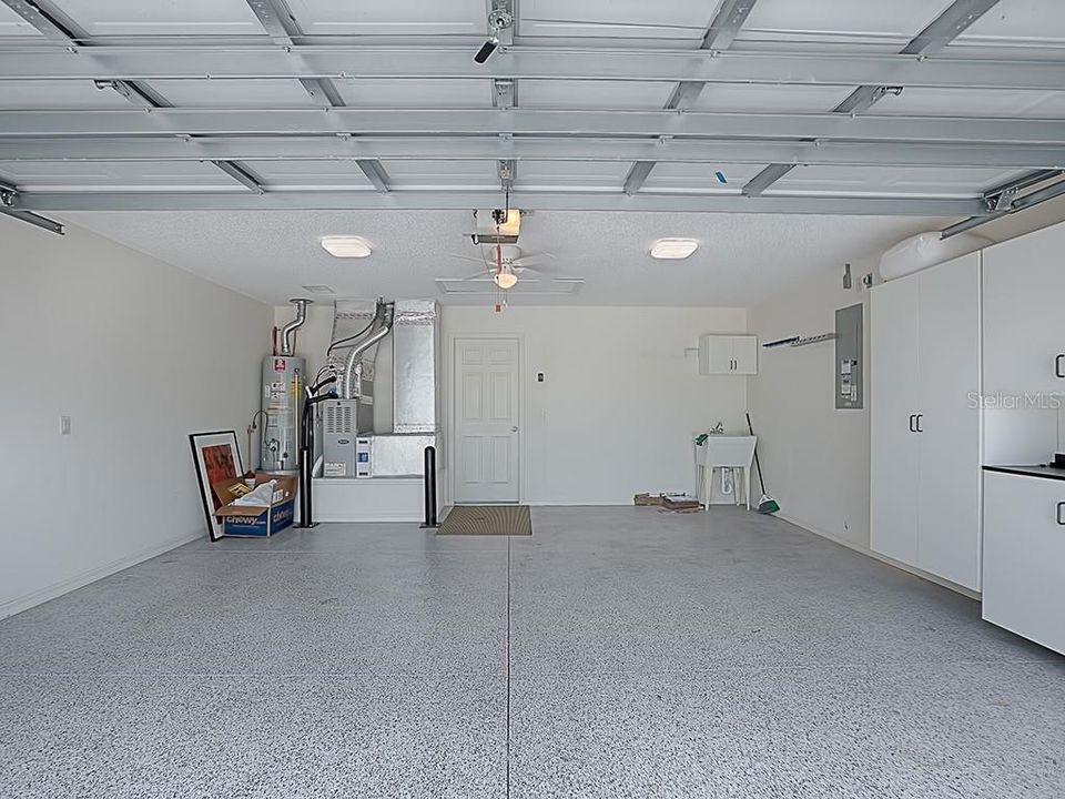 Large 2 Car Garage With Painted Floors and Extra Cabinets.