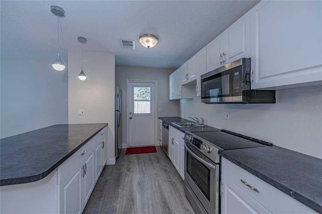 Kitchen with stainless appliances and a breakfast bar! Entry from carport too!