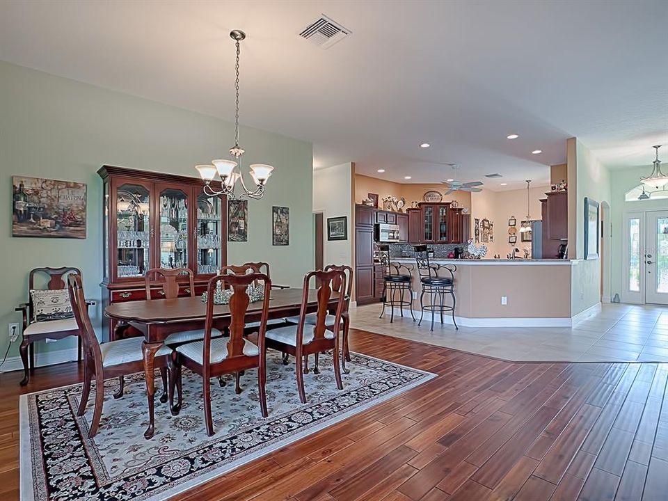 A VIEW OF THE SPACIOUS DINING ROOM AREA WITH BEAUTIFUL FLOORING