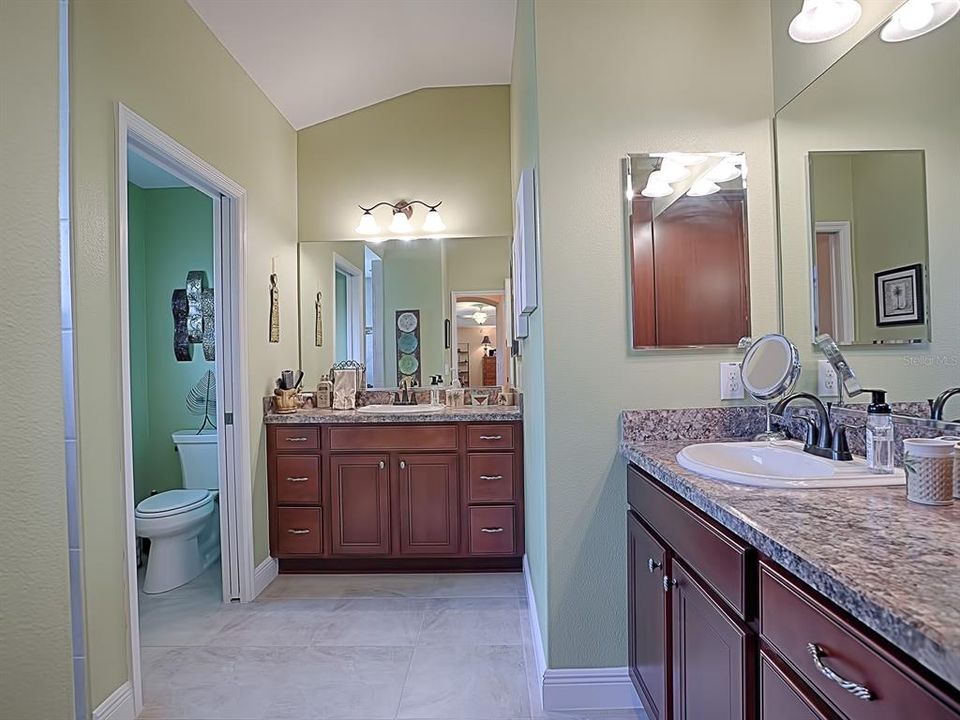 THE MASTER BATH HAS DUAL VANITIES & SINKS AND A SEPARATE WATER CLOSET  AREA WITH SLIDING POCKET DOOR