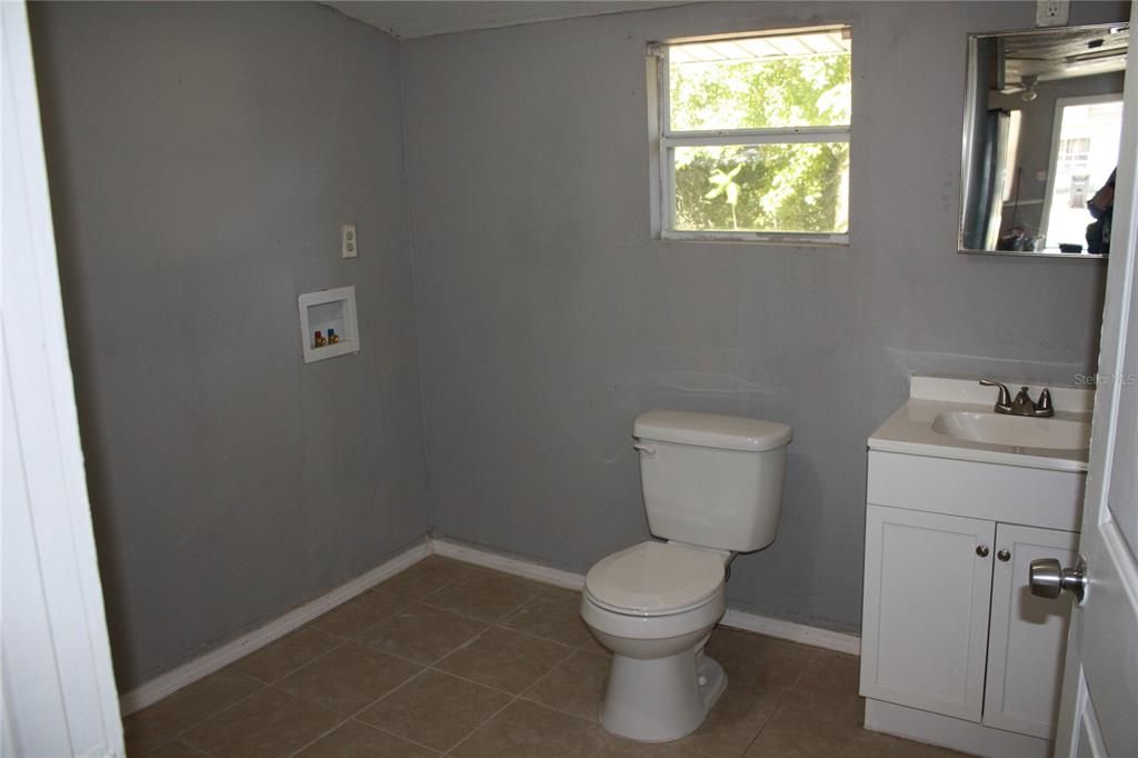 Large tiled master bathroom with washer-dryer hookup