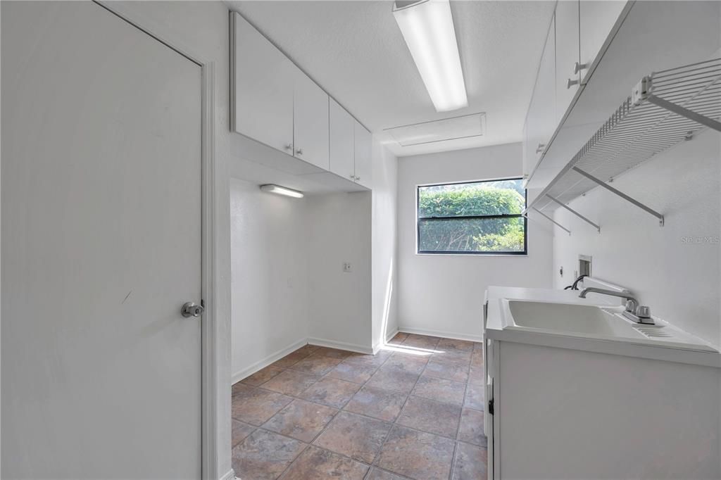 Large inside laundry room with sink and storage cabinets