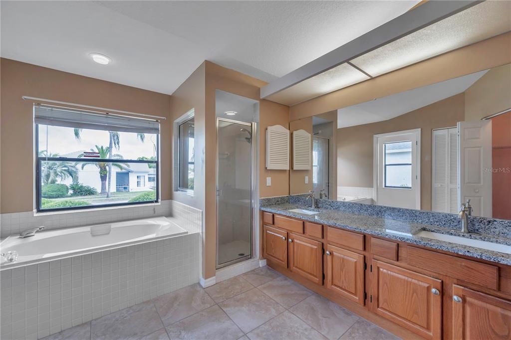 Master bathroom with private water closet, garden tub, stand-up shower and double sinks with granite counters.