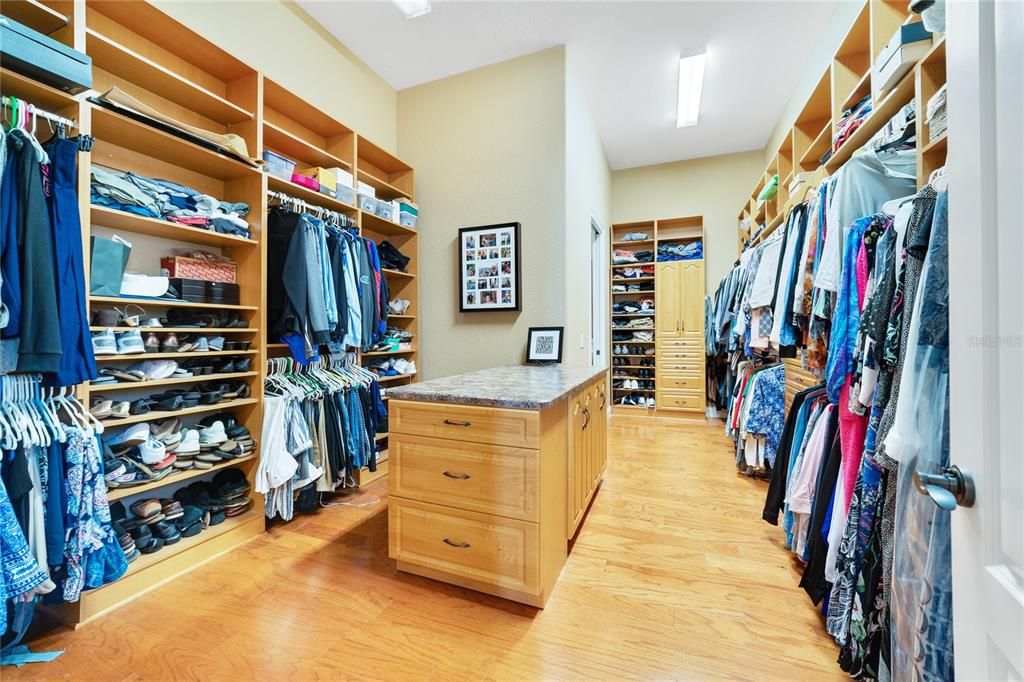 Walk in closet with tons of built ins, storage and access to the laundry room.