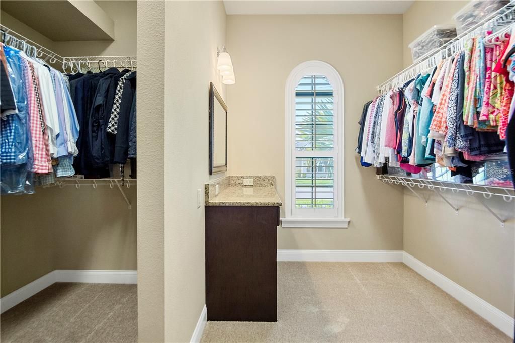 His and her master closets with natural light and a customized sit-down vanity.
