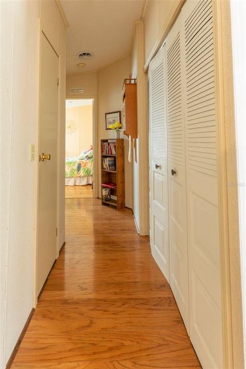 Hallway leading to the 2nd bedroom and bath.  Linen closet to the left and washer& dryer are to the right in the double closet.