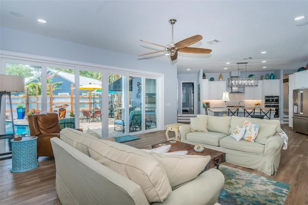 Living Room with all of windows overlooking the outdoor kitchen, salt water pool and spa.