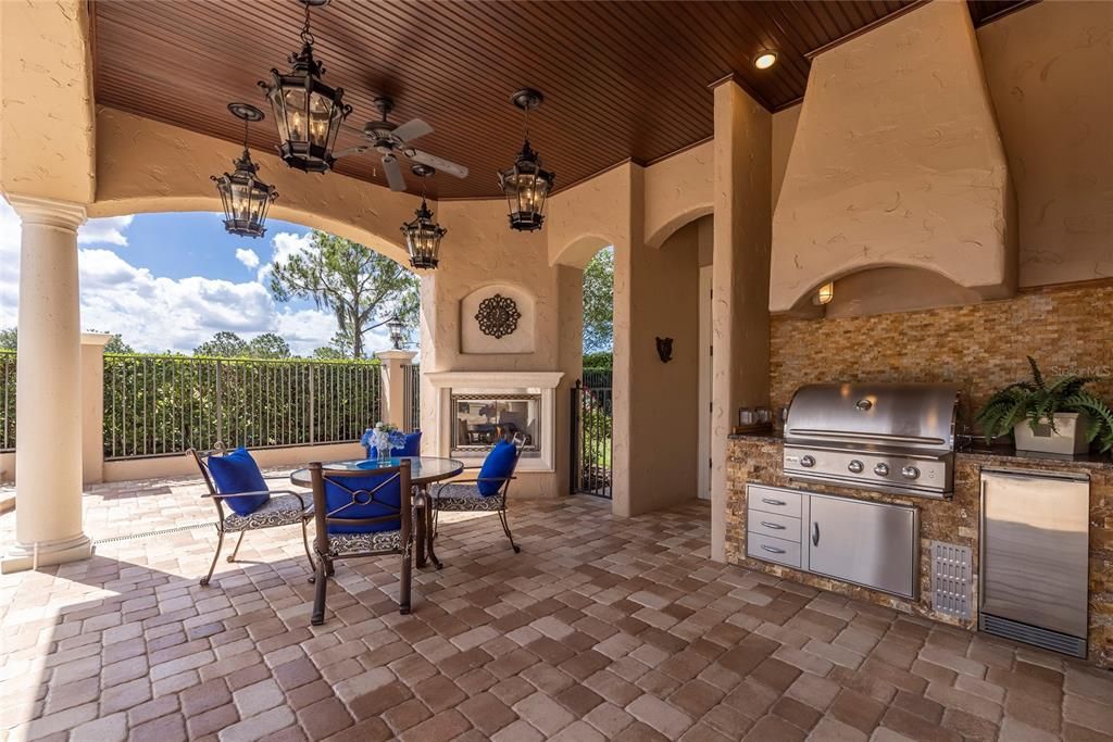 Covered lanai with outdoor kitchen, outdoor natural gas fireplace, and beautiful wood ceilings. Outdoor storage closet and pool bath access from the lanai.