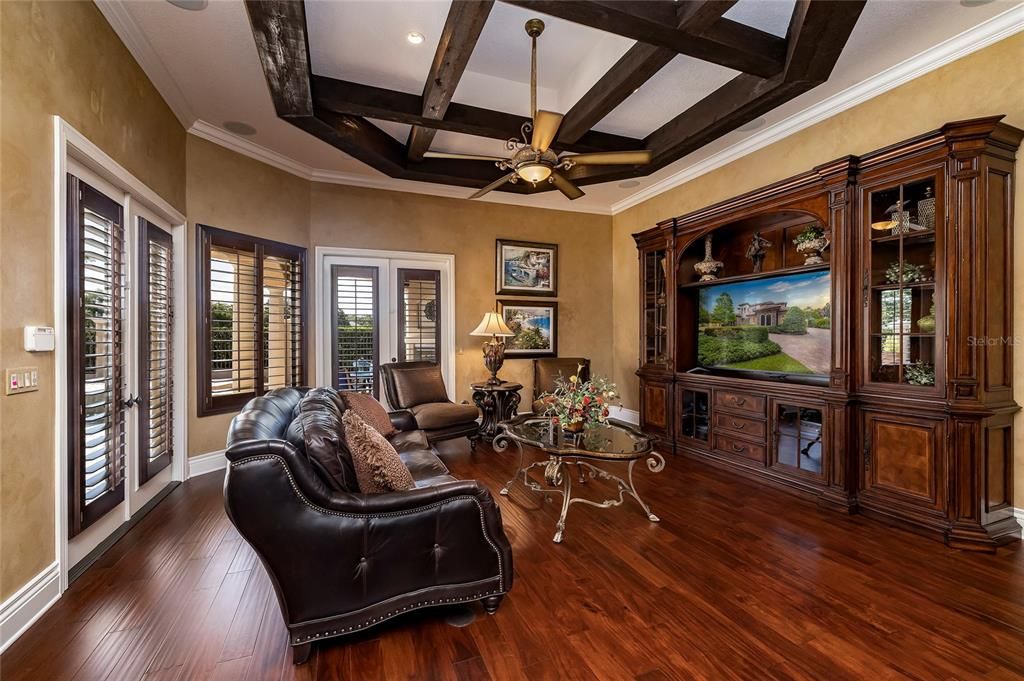 The kitchen opens to the family room. New engineered hardwood floors, beam ceiling, French doors to the lanai, and French doors to the media/game room. An audio system plays music throughout the home.