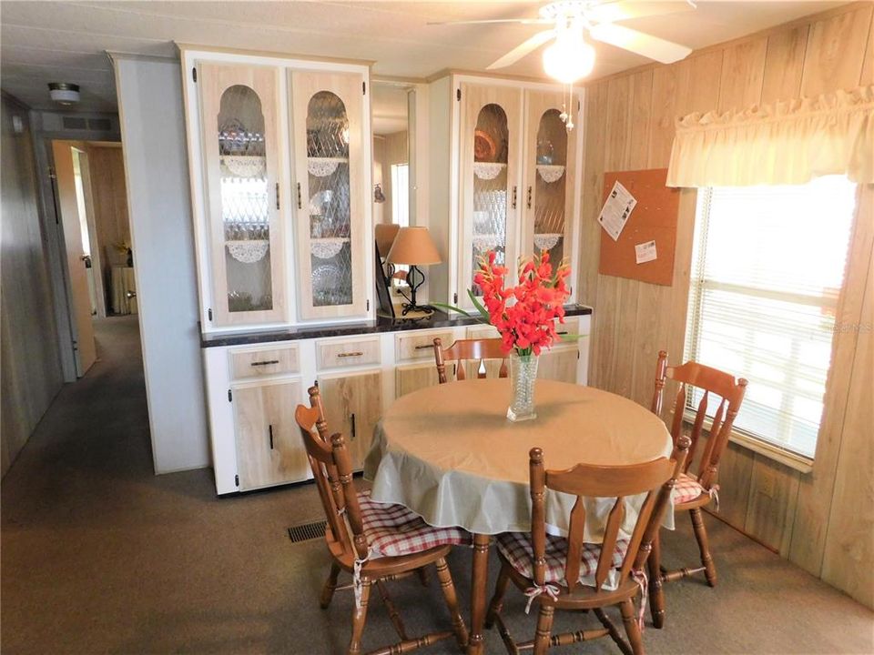 Nice built-in storage and ceiling fan in dining area.