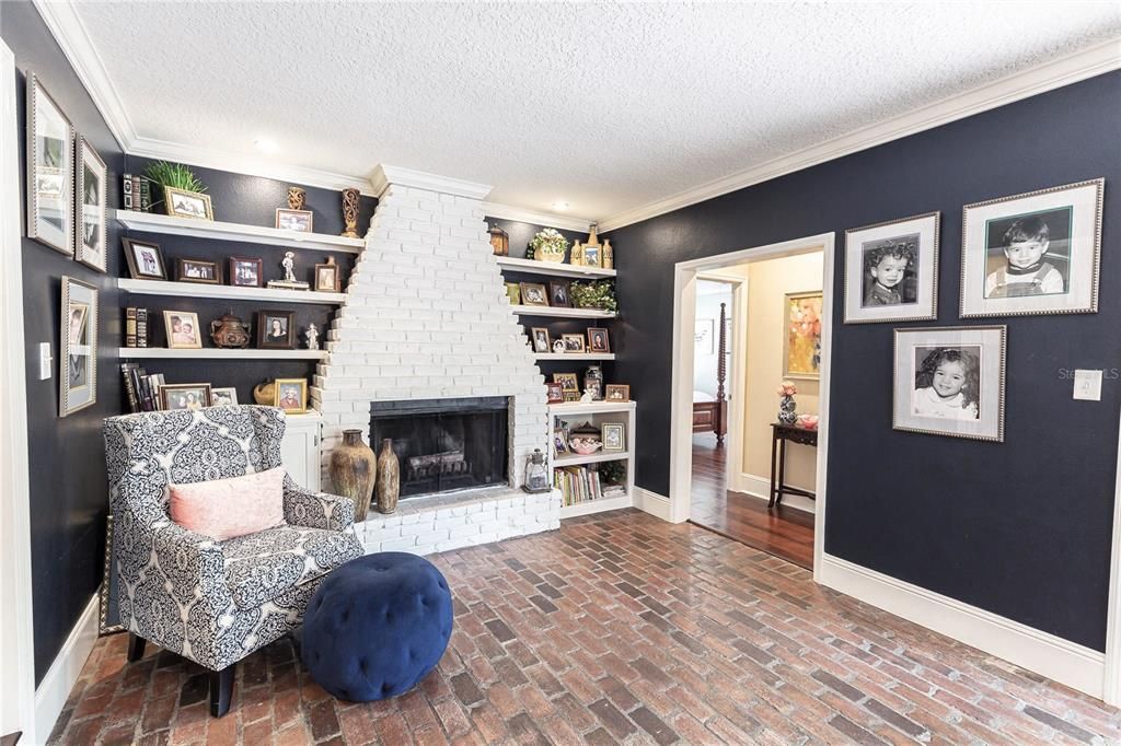 Absolutely charming brick-paved Family Room located towards the Back of the house with fireplace and builtins.